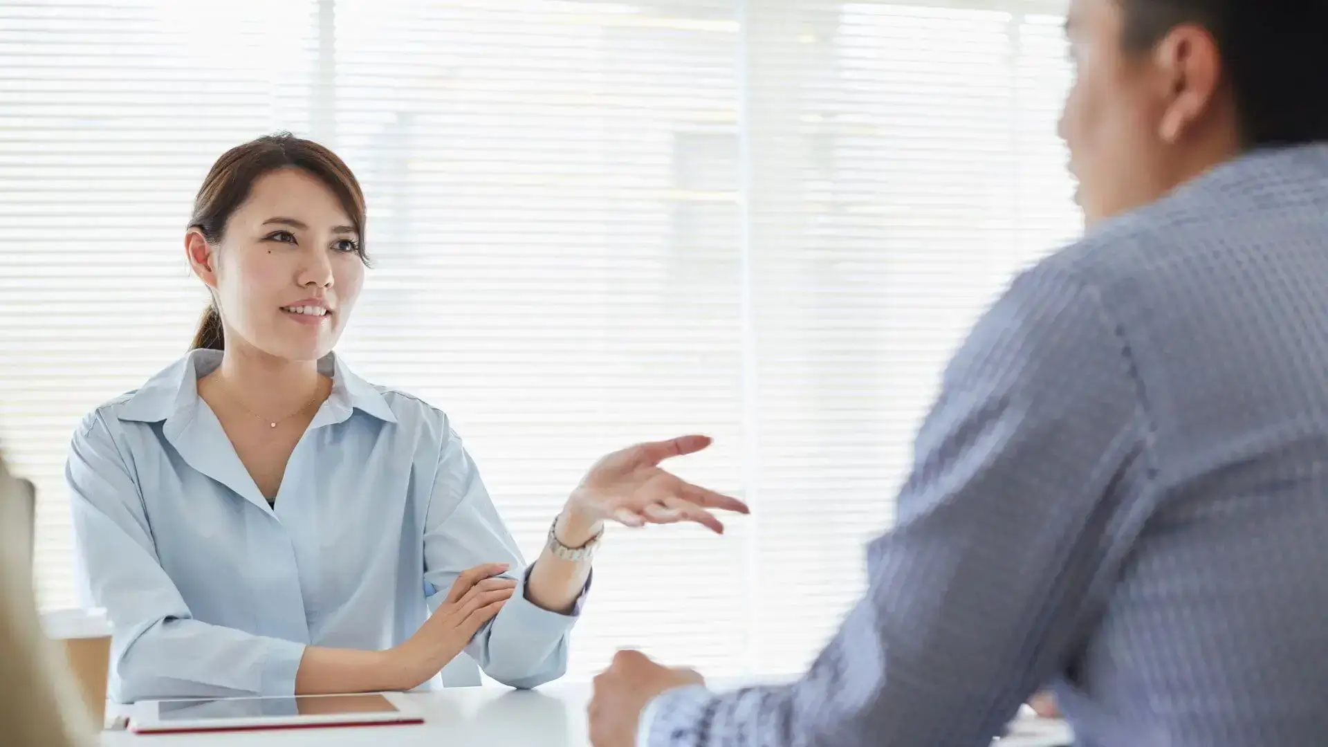 Conseillère en entretien avec un client, échangeant lors d’un rendez-vous, pour illustrer l’analyse des besoins en assurance et prévoyance.