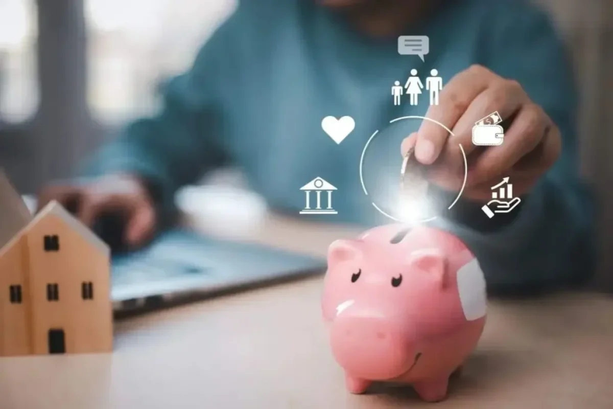 Personne déposant une pièce dans une tirelire, avec une maison miniature et des icônes financières, pour illustrer un service de financement.