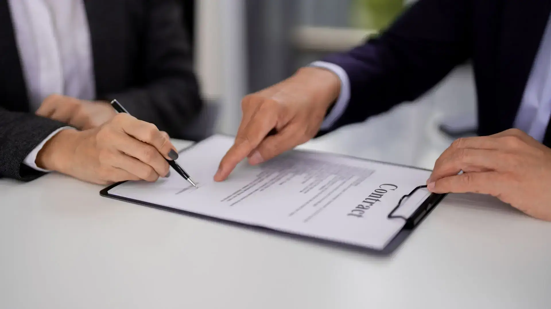 Deux professionnels examinent et signent un contrat, pour illustrer la négociation des conditions dans un projet d’investissement immobilier.
