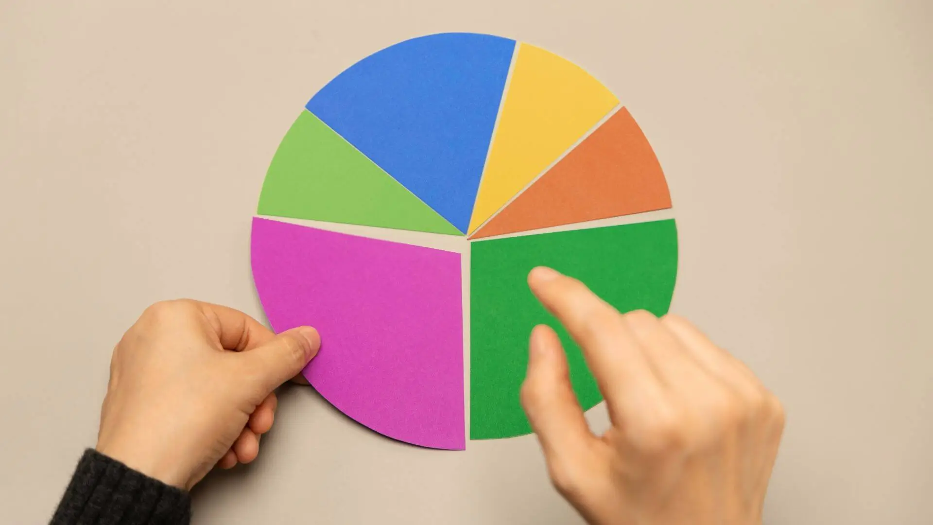 securite-diversification-placements-financiers-lyon Mains ajustant un diagramme circulaire coloré, pour illustrer la sécurité et la diversification des placements financiers.